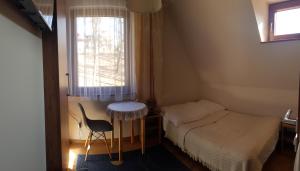a small bedroom with a bed and a window at Willa Parkowa in Szczawnica