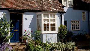 une maison bleue et blanche avec une porte bleue dans l'établissement The Old Stables B&B, à Winslow