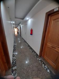 an empty hallway with a fire extinguisher on the wall at Hotel Zoon Dabb Srinagar airport kashmir in Srinagar