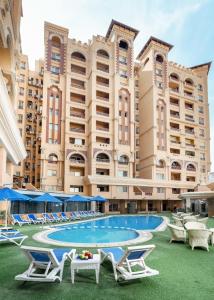 a large building with a pool and lounge chairs at Eastern Al Montazah Hotel in Alexandria