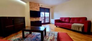 sala de estar con sofá rojo y mesa en Apartament Widokowy Maki, en Zakopane