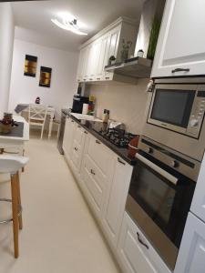 a kitchen with a stove and a microwave at Apartament Luxury in Vişeu de Sus +40 photos
