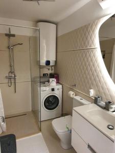 a bathroom with a toilet and a washing machine at Apartament Luxury in Vişeu de Sus