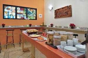 una mesa con comida en ella con platos y tazas en HOTEL & HOSTEL RIBEIRAo en Ribeirão Preto