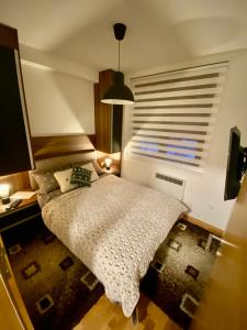 um pequeno quarto com uma cama e uma janela em Zlatiborske Noći em Zlatibor