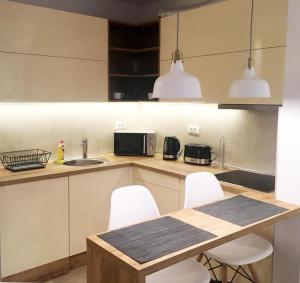 a kitchen with a table and white chairs in it at Apartment SUN CITY 1 in Belgrade +7 photos