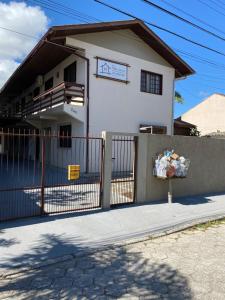 una casa blanca con una valla delante en Pousada Villa Garcia - Residencial, en Florianópolis