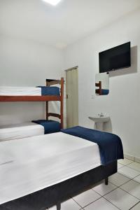 a room with two bunk beds and a flat screen tv at HOTEL & HOSTEL RIBEIRAo in Ribeirão Preto