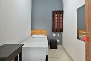 リベイラン・プレトにあるHOTEL & HOSTEL RIBEIRAoのベッドとテーブル付きの小さな部屋