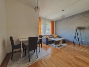 a living room with a table and a couch at Zara 1 Apartman in Bijeljina
