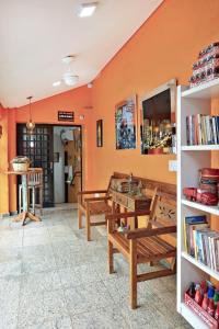 a room with two benches and a table and books at HOTEL & HOSTEL RIBEIRAo in Ribeirão Preto