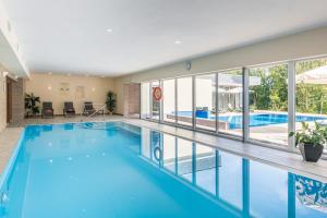 a large swimming pool with blue water in a building at Akzent Aktiv & Vital Hotel Thüringen in Schmalkalden