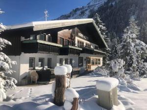 un grand bâtiment dans la neige avec des arbres enneigés dans l'établissement Norishütte, à Mittelberg