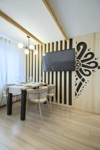 a dining room with a table and a tv on a wall at Dom Wczasowy U Eli - ruska bania, sauna na wyłączność in Białka Tatrzańska