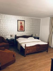 a bedroom with a large bed and a couch at Pensiunea Royal in Ranca