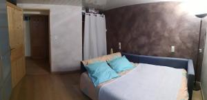 Habitación con sofá y 2 almohadas azules. en Suite cosy 2 chambres et sdb privative en Blagnac