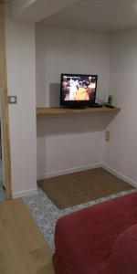 sala de estar con TV en la pared en Suite cosy 2 chambres et sdb privative, en Blagnac