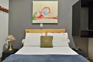a bedroom with a bed and a painting on the wall at Ribeirão Plaza Hotel in Ribeirão Preto