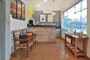 comedor con sillas, mesa y pared de ladrillo en Ribeirão Plaza Hotel, en Ribeirão Preto