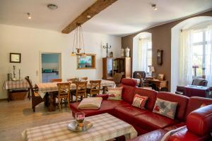 a living room with a red couch and a dining room at Schloss Stiege in Stiege