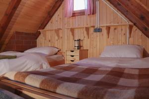 a bedroom with two beds in a wooden cabin at CHALET Kocna - I FEEL ALPS in Stahovica