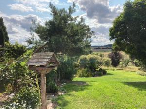 a bird house on a wooden post in a garden at Balkonzimmer Pension Volgenandt in Breitenbach