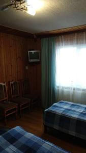 a bedroom with two beds and a window and a tv at Kray Dorogy in Yaremche