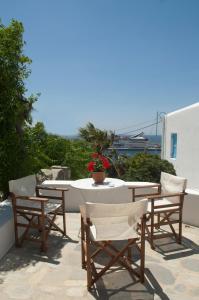 a table and chairs on a patio with a table and flowers at Megas Rooms in Tourlos