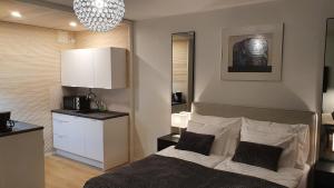 a bedroom with a bed and a kitchen with a chandelier at Myplace in Oulu Studio Koulukatu in Oulu
