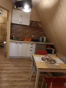 コシチェリスコにあるPokoje gościnne Zosiaの白いキャビネットと木製テーブル付きのキッチン