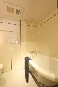 Un baño blanco con lavabo y ducha. en Shinjuku 1003, en Tokio