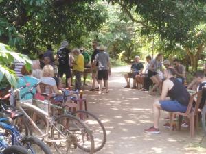 a group of people sitting in chairs under trees at Udesh Guest in Polonnaruwa