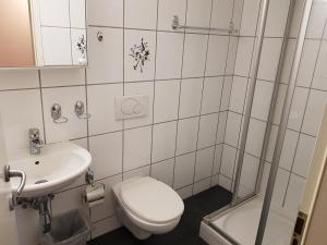 a white toilet sitting next to a white sink in a bathroom at Bellpark Hostel in Luzern