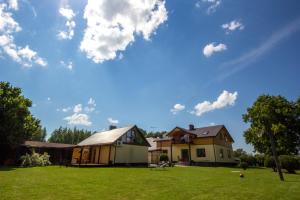 a house on a lawn with a blue sky at Brīvdienu mājas Pārupes in Bauska