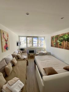 a living room with a large bed and a couch at Studio centre village au pied des pistes in Allos
