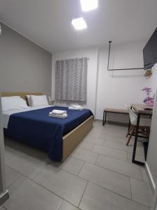 Schlafzimmer mit einem Bett, einem Tisch und einem Schreibtisch in der Unterkunft GiglioApartment Etna Mare in Aci Castello