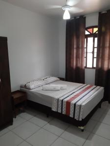 een slaapkamer met een bed in een kamer bij Casa de praia em Guarapari - Santa Mônica. in Guarapari