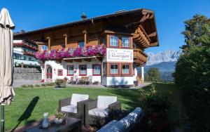 dom z krzesłami i kwiatami przed nim w obiekcie Landhaus Rosengartl w Schladming