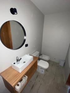 a bathroom with a sink and a toilet and a mirror at 126 Suite “Centro” in Suipacha