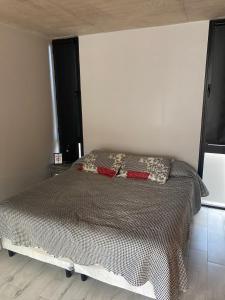 1 dormitorio con 1 cama con edredón blanco y negro en 126 Suite “Centro” en Suipacha
