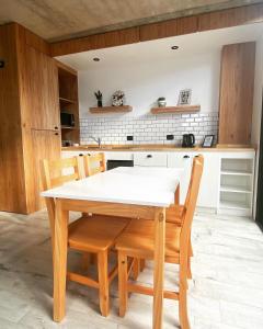 uma cozinha com uma mesa branca e cadeiras de madeira em 126 Suite “Centro” em Suipacha
