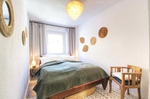 1 dormitorio con 1 cama, 1 silla y 1 ventana en Erzgebirge Suite Bergruhe, en Kurort Oberwiesenthal