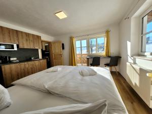 sypialnia z dużym białym łóżkiem i biurkiem w obiekcie Ferienwohnung Flachau Oberlehengut w mieście Flachau