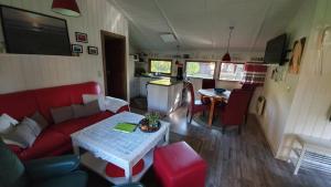 ein Wohnzimmer mit einem roten Sofa und einem Tisch in der Unterkunft Lille Hus in Gartow