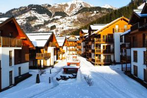 a group of buildings in the snow in front of a mountain at Modern Mountain Apart directly by Skiing area in Rauris