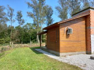 a small wooden building with a air conditioner on it at Pousada Encantos Da Montanha in Louro Müller