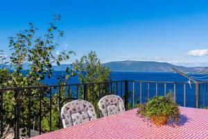 a table and chairs with a view of the ocean at Apartmani Valun1 in Valun