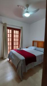 1 dormitorio con 1 cama y ventilador de techo en Flat em Lençóis apartamento 003, en Lençóis