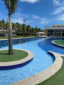 uma piscina com azulejos azuis e uma palmeira em Muro Alto Condomínio Clube Apt 316 em Porto de Galinhas