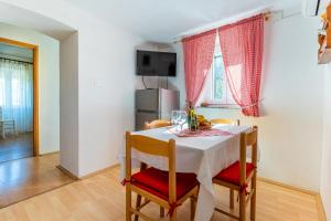 a dining room with a white table and chairs at Apartmani Valun1 in Valun
